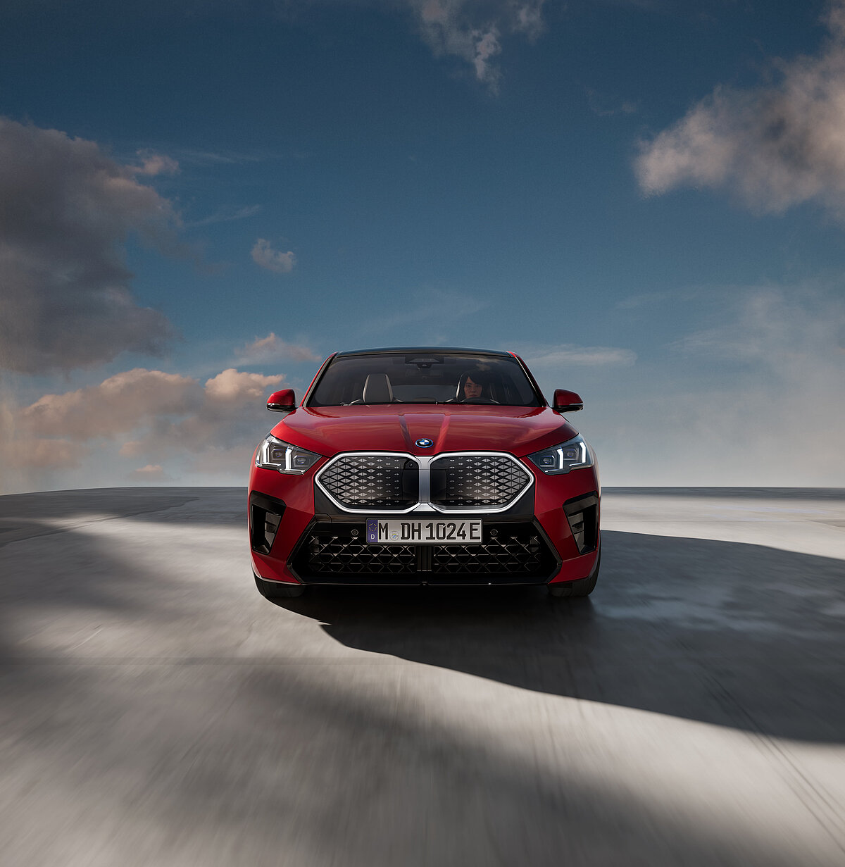 Rotes BMW-Elektroauto steht auf einer grauen Betonebene