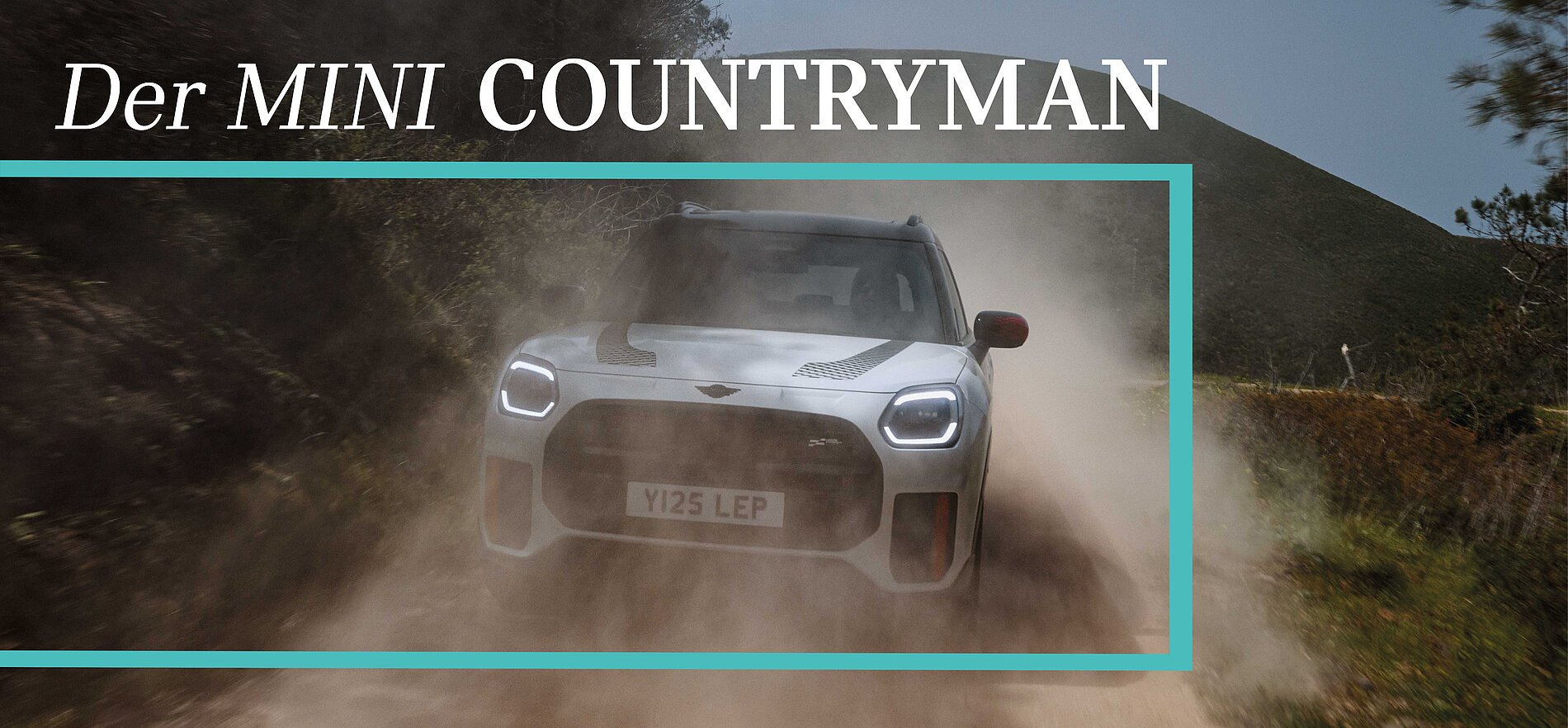 Weißer Mini Countryman fährt staubig auf Landstraße