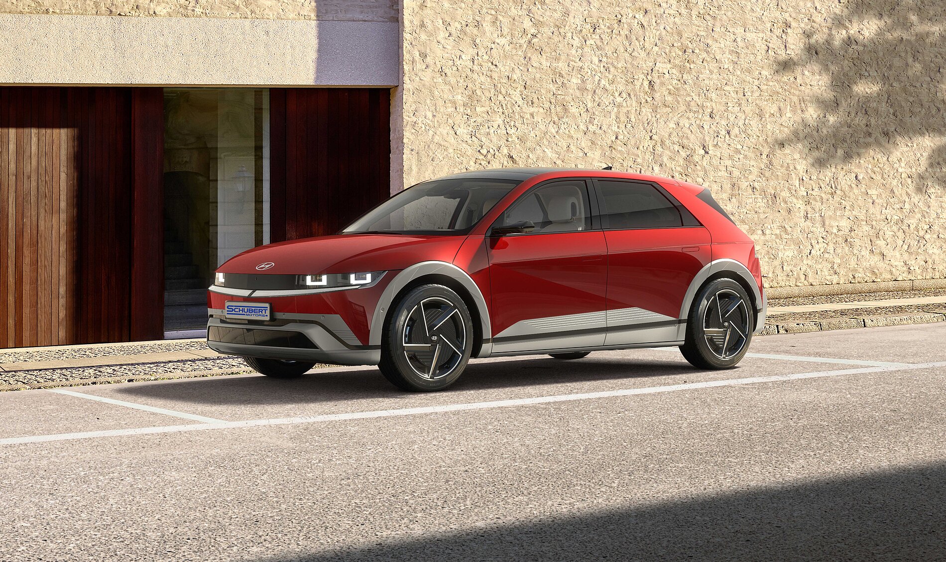 Rotes modernes Elektroauto steht vor Backsteingebäude
