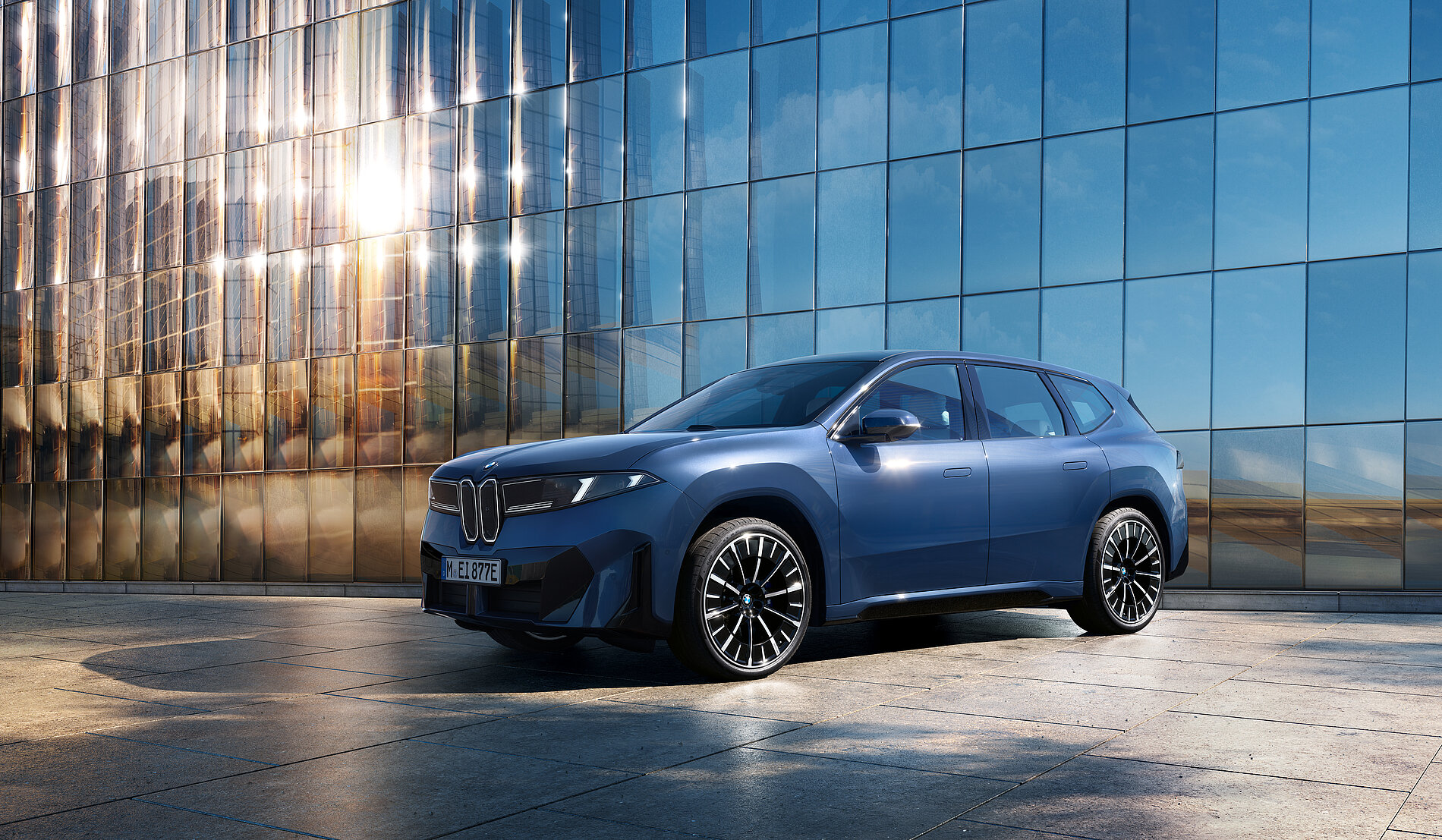 Blauer BMW Elektro-SUV vor moderner Glasfassade
