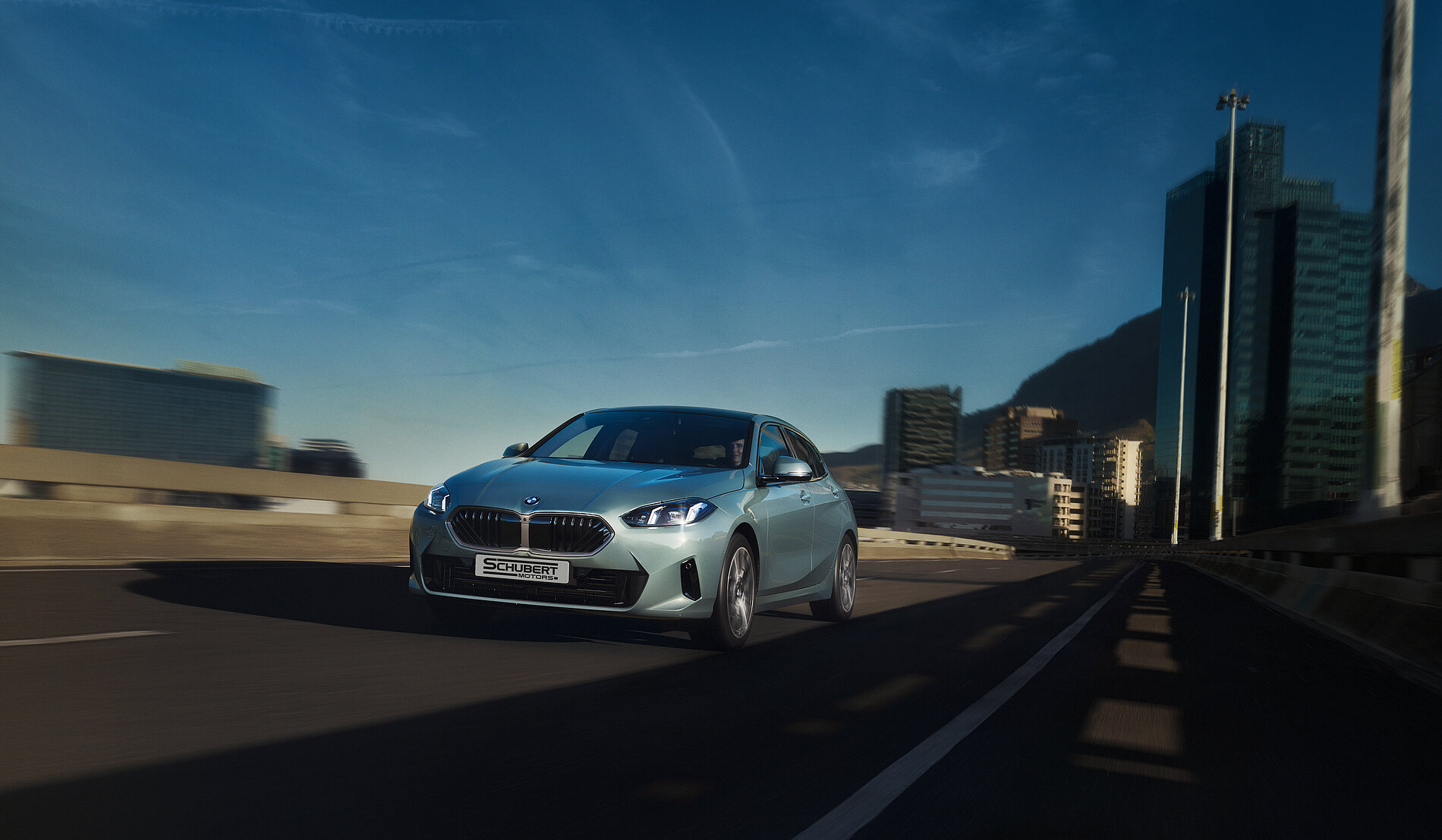 Weißes BMW-Kompaktwagen fährt auf urbaner Autobahn